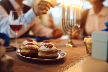Naklejka premium Jewish traditional sufganiyah donuts with couple in background.