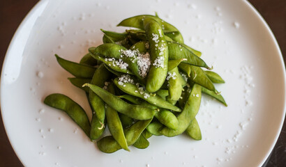 Slated EDAMAME beans served in a dish isolated on table side view