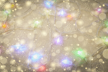 Abstract Christmas background with golden snowflakes and a garland with colorful lights.