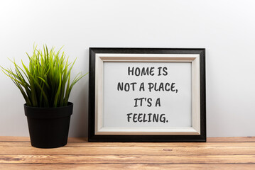 Inspirational quotes text in a frame - home is not a place, it's a feeling.