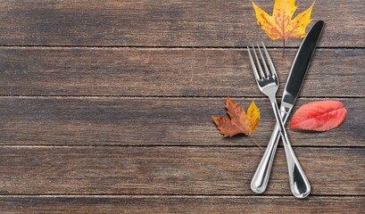 Colored autumn leaves with fork and knife on the desk