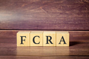 FCRA - Fair Credit Reporting Act, word written on wooden blocks on wooden table.