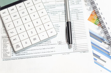 Naklejka na ściany i meble US Individual Tax Return Form 1040 with calculator and pen