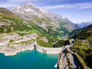 Water dam and reservoir lake aerial view in Alps mountains generating hydroelectricity. Low CO2...