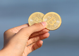 golden coins symbolizing bitcoins in hand