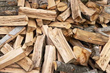 Sawn and chopped firewood for home heating during the cold season. Energy, energy crisis, heat, fuel. Selective focus, background.