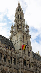 Fototapeta premium Brussels town hall and the belgian flag in Grand Place