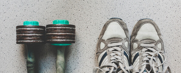 Vintage sport shoes and dumbbells on the floor