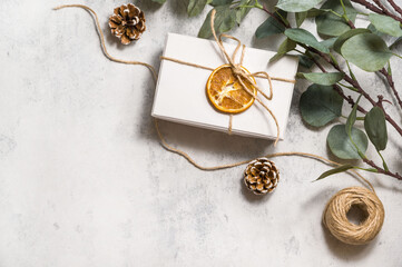 Christmas or new year flatlay with Recycled gift box, eucalyptus,twine and pine cones. Banner with...