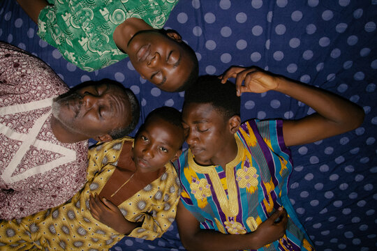 A father and his four children laying down