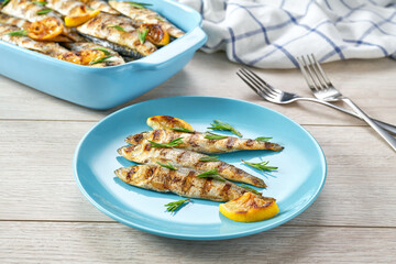 Grilled sardines with addition of fresh herbs, lemon and spices on a wooden background. Grilled seafood, barbecue.