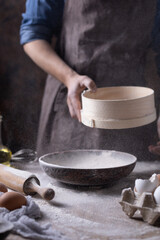Man sifting flour through sieve for bread and bakery ingredients, homemade pasta cooking on table