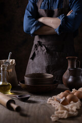 Baker man and flour with bakery ingredients for homemade bread cooking at table