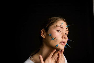 young beautiful girl with deep eyes looking into the camera. needles from syringes and arrows are...