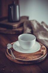 Empty cup of coffee and kettle beans at wood table. Homemade coffee on table