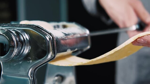 Close up footage of female chef stretching dough for pasta.