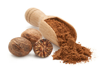 Zmielona gałka muszkatołowa na drewnianej łopatce rozsypana na białym tle