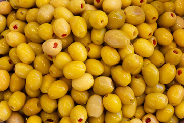 Pickled olives laid out in an even layer, juicy delicious color. Food texture background.