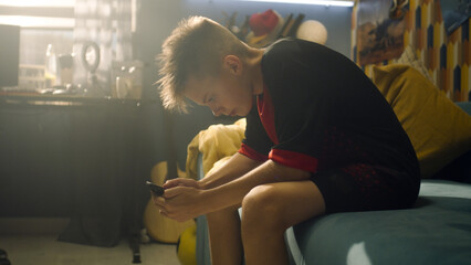 Schoolboy sits on the couch and uses his phone. Picks up his backpack from the carpet and then...