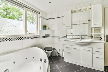 Shower faucets attached to tiled wall near glass partition and ornamental curtail in washroom at...