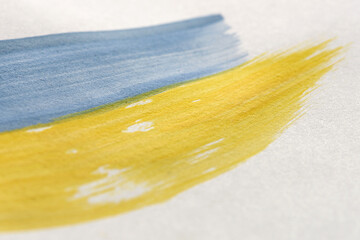 Hand drawn flag of Ukraine. Yellow and blue strokes of paint on white isolated background. The national symbol of the country. Flag concept with colorful brush strokes. UA. Close-up macro shot.