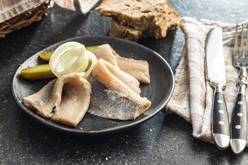 Marinated herring fish on plate.