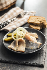 Marinated herring fish on plate.