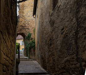 view up a narrow street between buildings of a beautifully preserved 14th century medieval town