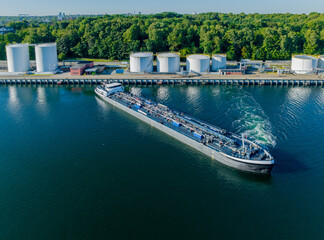 Oil tanker  sailed out from an oil storage silo terminal after unloading. Aerial view of oil...
