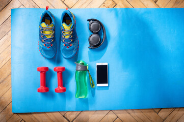 Sneakers, dumbbells, water and headphones. Home workout with dumbbells and music. Fitness training...