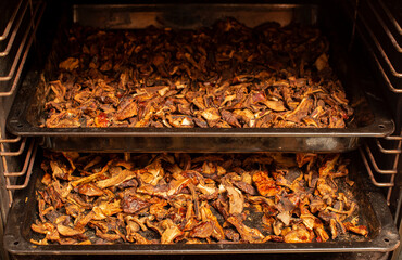 Dry mushrooms on a baking tray in a home oven. Long-lasting food product