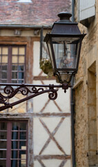 old black cast iron street lamps fitted with modern LED bulbs in a medieval town