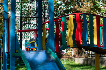 Fototapeta na wymiar Bright multi-colored playground in courtyard of multi-storey buildings in residential area