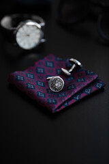 Business accessories. Luxury Men's cufflinks with watch, breastplate and sunglasses close up.