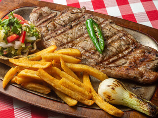 grilled steak with vegetables and fries