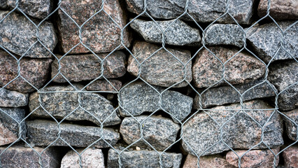 texture of a rocky wall behind an iron fence