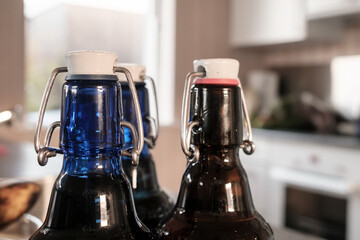 Three bottles of beer, closed with convenient caps, on a blurred background. 