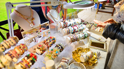 Beautiful woman trying on hand made bracelets with gemstones.