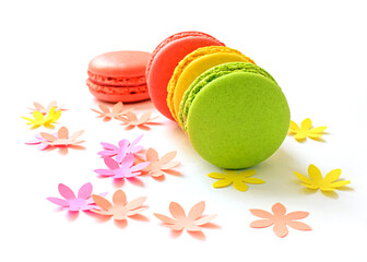 Colorful Macarons cake on white background with paper flowers and copy space. Sweet and colorful french macaroons on white background.