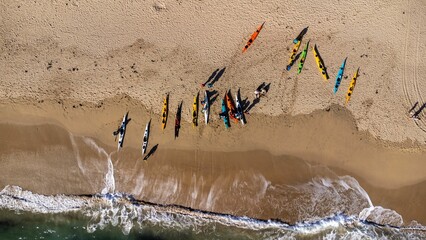 Fototapeta premium Aerial view of colorful Kayak boats on the shore of a beach