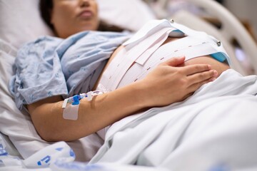 A pregnant woman in the hospital with a iv drip and a cardiograph. Childbirth and labor.