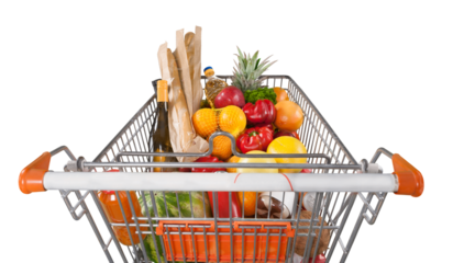 Shopping cart filled with various groceries in store