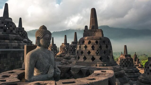 Zoom out timelapse of tourists exploring the ancient ruins of Borobudur, a 9th-century Mahayana Buddhist temple in Magelang Regency near Yogyakarta in Central Java, Indonesia.