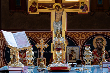 Inside the altar of an orthodox church, with traditional artifacts and the richly decorated cross...