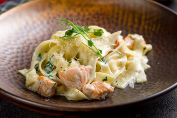 fettuccine with salmon and creamy sauce with parmesan macro close up