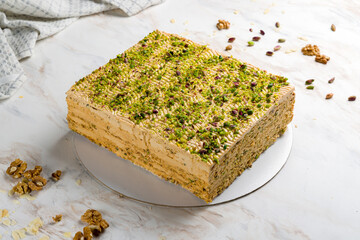 pistachio cake on white marble table side view