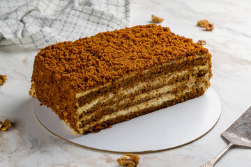 honey cake on white marble table side view