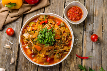 Lagman asian soup with beef and noodles on old wooden table top view
