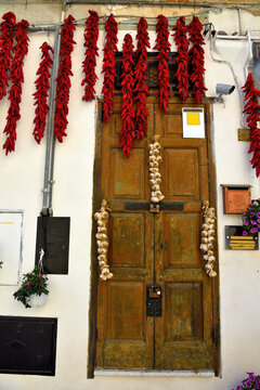 red chillies and onions hanging in the historic center of montalbano jonico basilicata italy