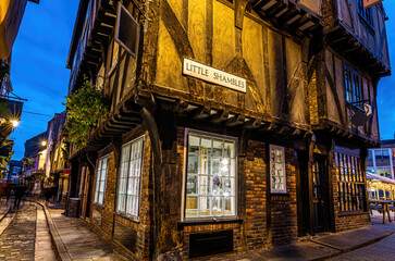 Fototapeta premium A Chirstmas night view of Shambles, a historic street in York featuring preserved medieval timber-framed buildings with jettied floors